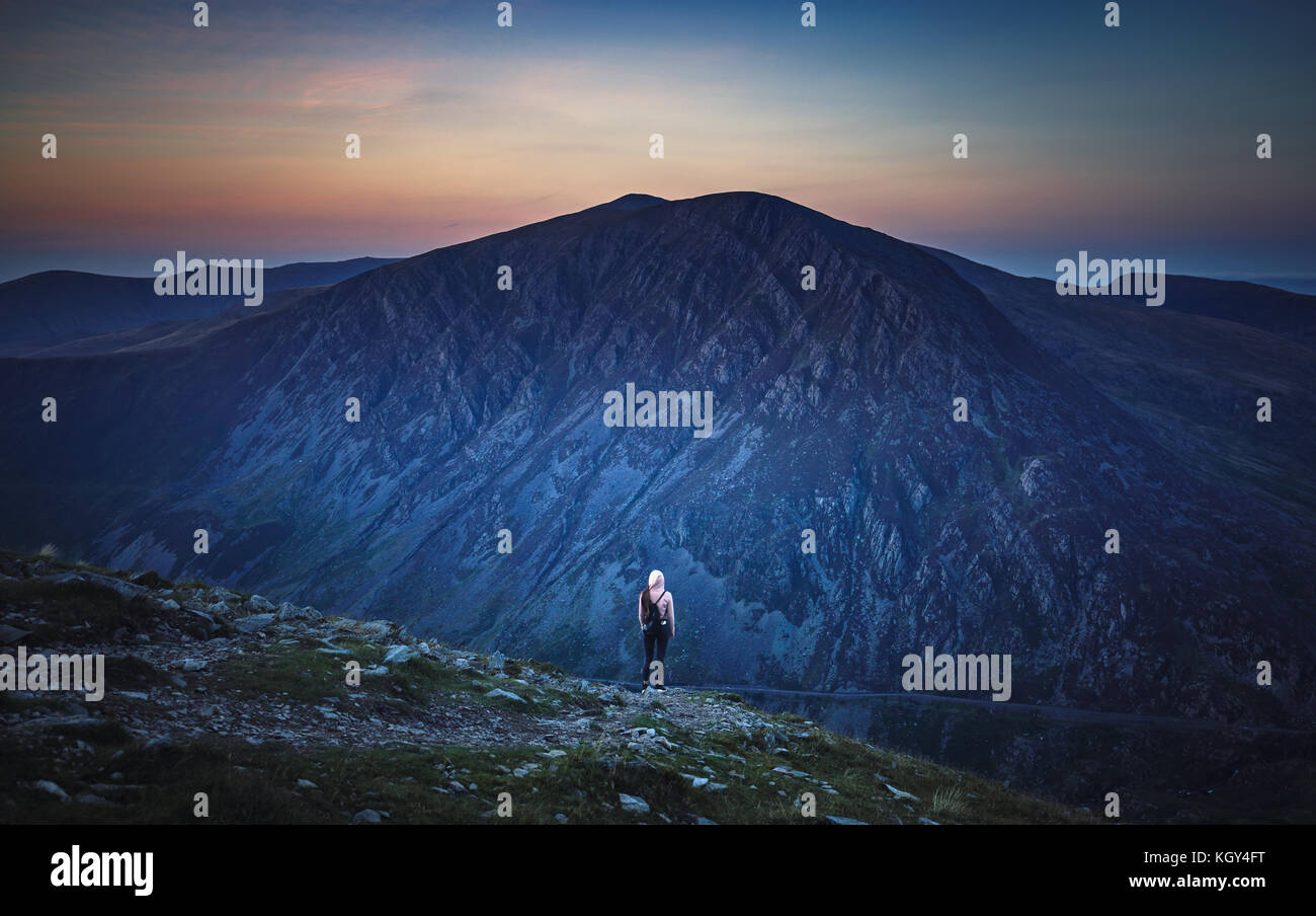 Female Hiker au sommet de la montagne au crépuscule Banque D'Images