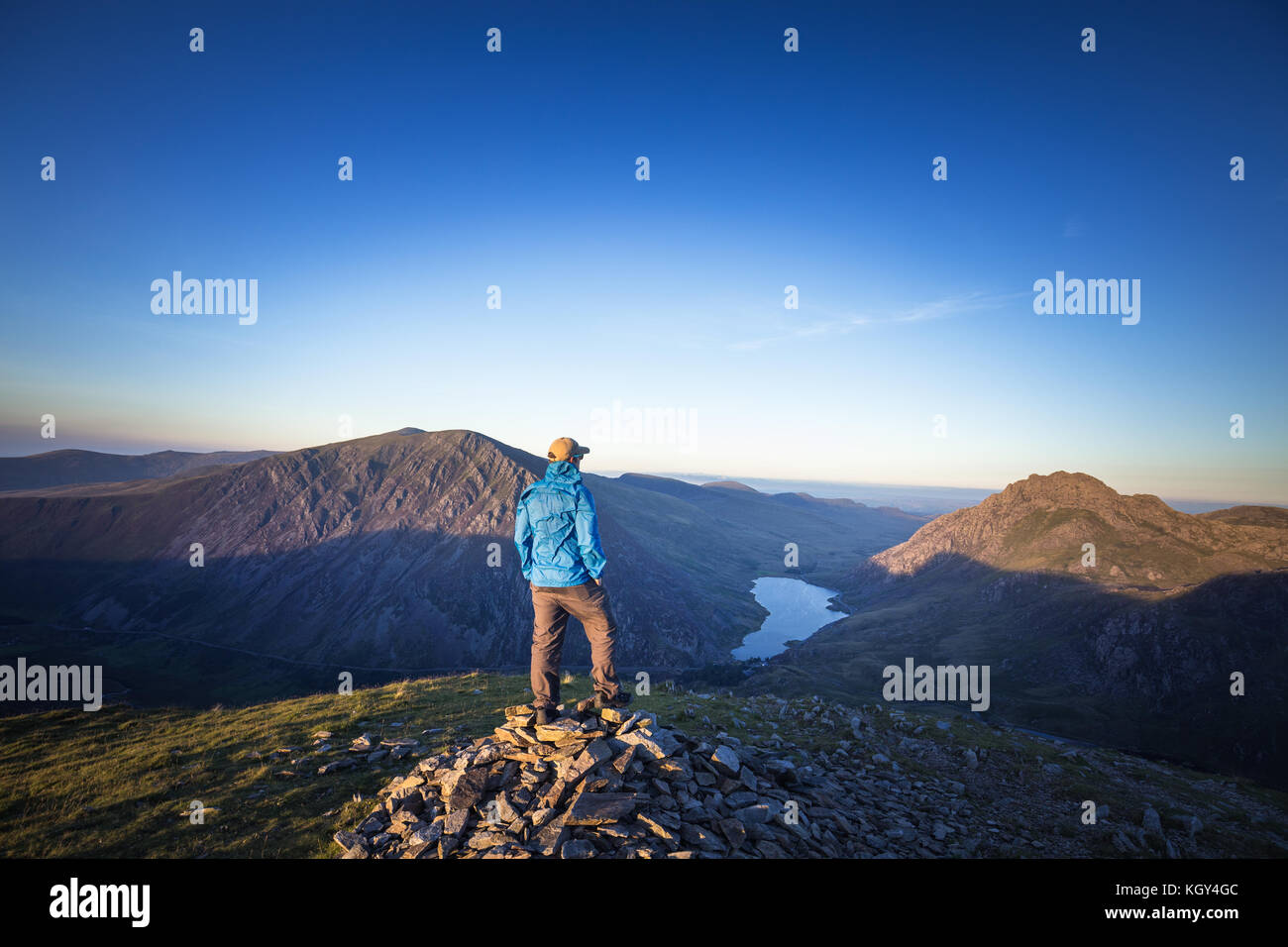 Young male Hiker en veste bleue sur le sommet de la Montagne Banque D'Images