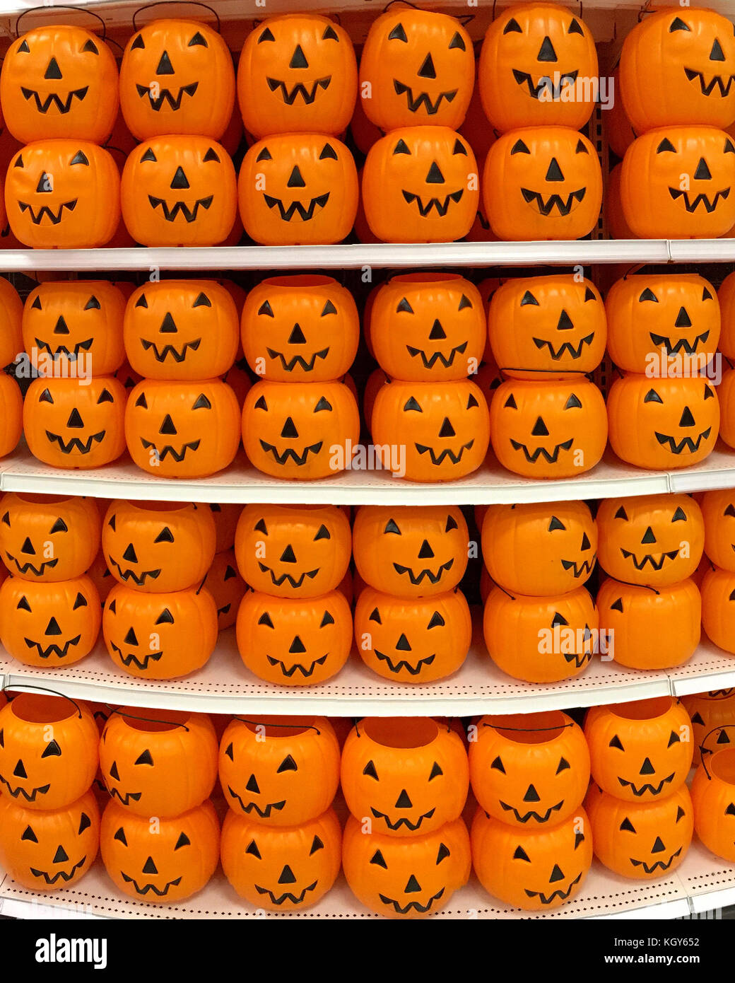 En plastique orange halloween citrouille Jack o lantern trick ou traiter les seaux et empilés en rangées sur une étagère magasin Shoppers prêt pour cette maison de vacances Banque D'Images