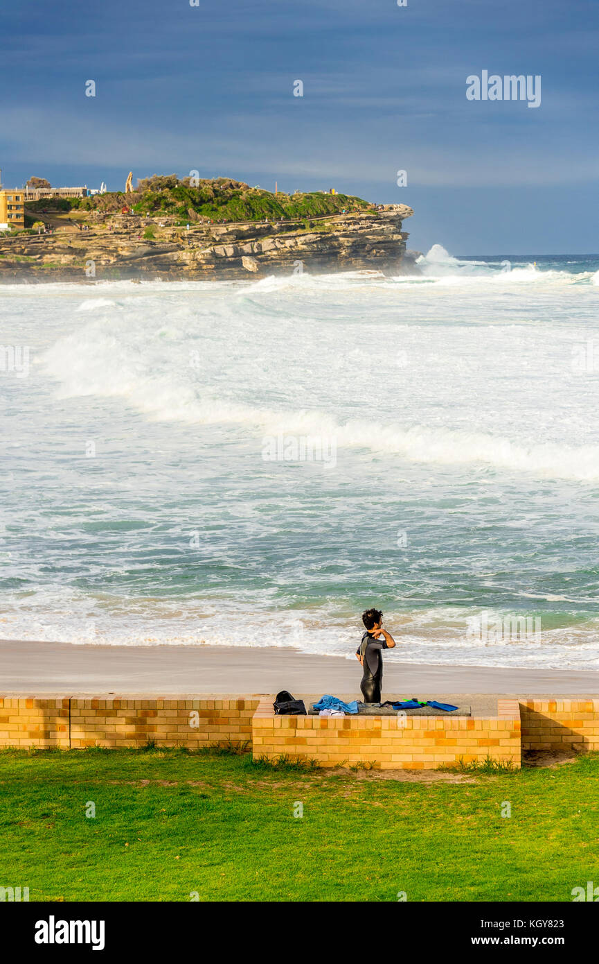 Un internaute prépare tout en regardant des conditions de surf à Bronte Beach à Sydney, NSW, Australie Banque D'Images
