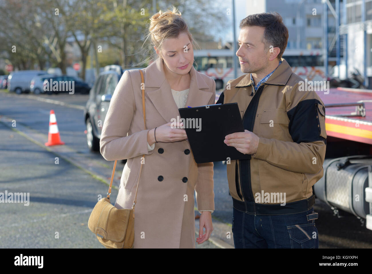 Femme avec le véhicule l'homme, documents de lecture Banque D'Images