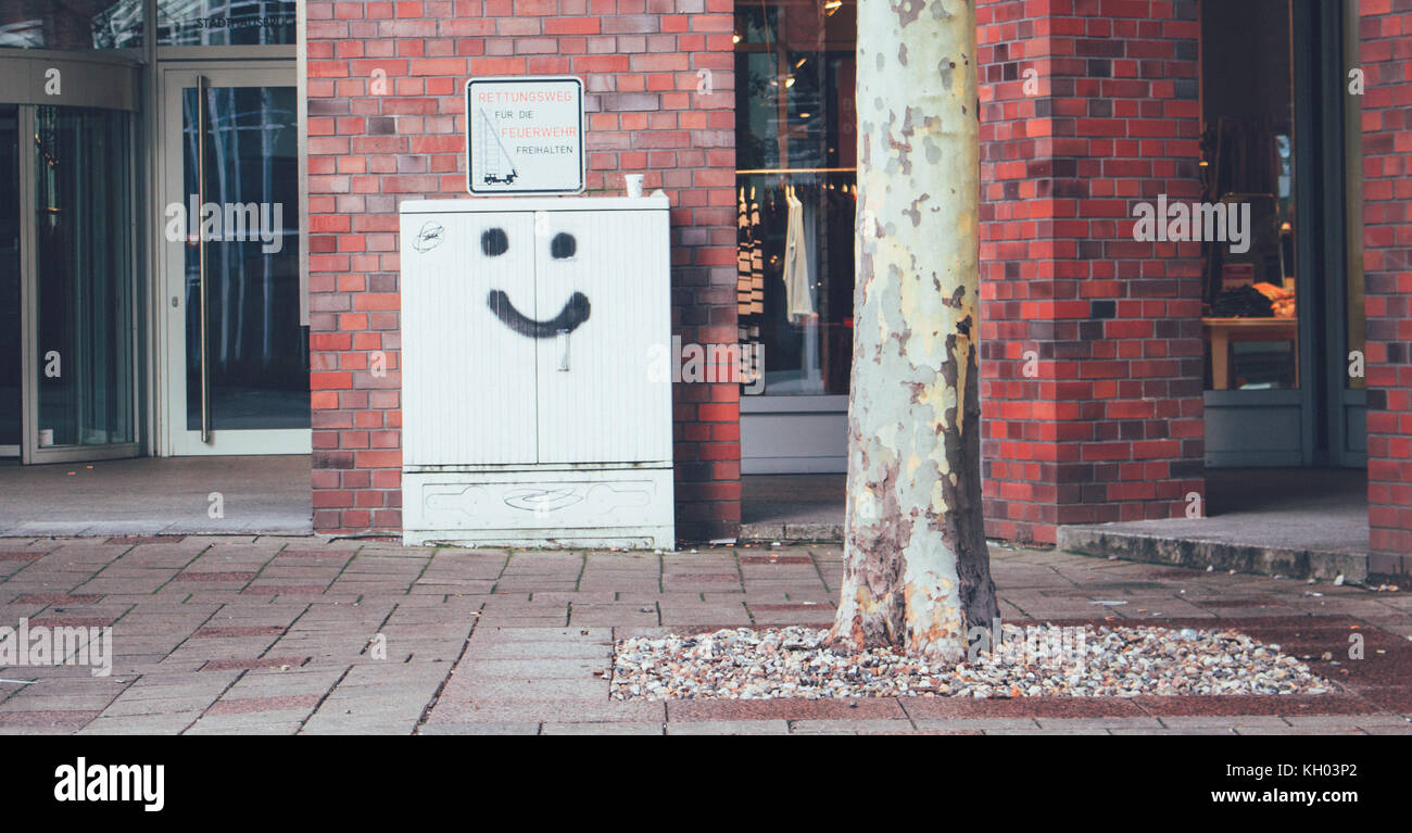 Visage sourire dans la rue graffiti sur un mur Banque D'Images