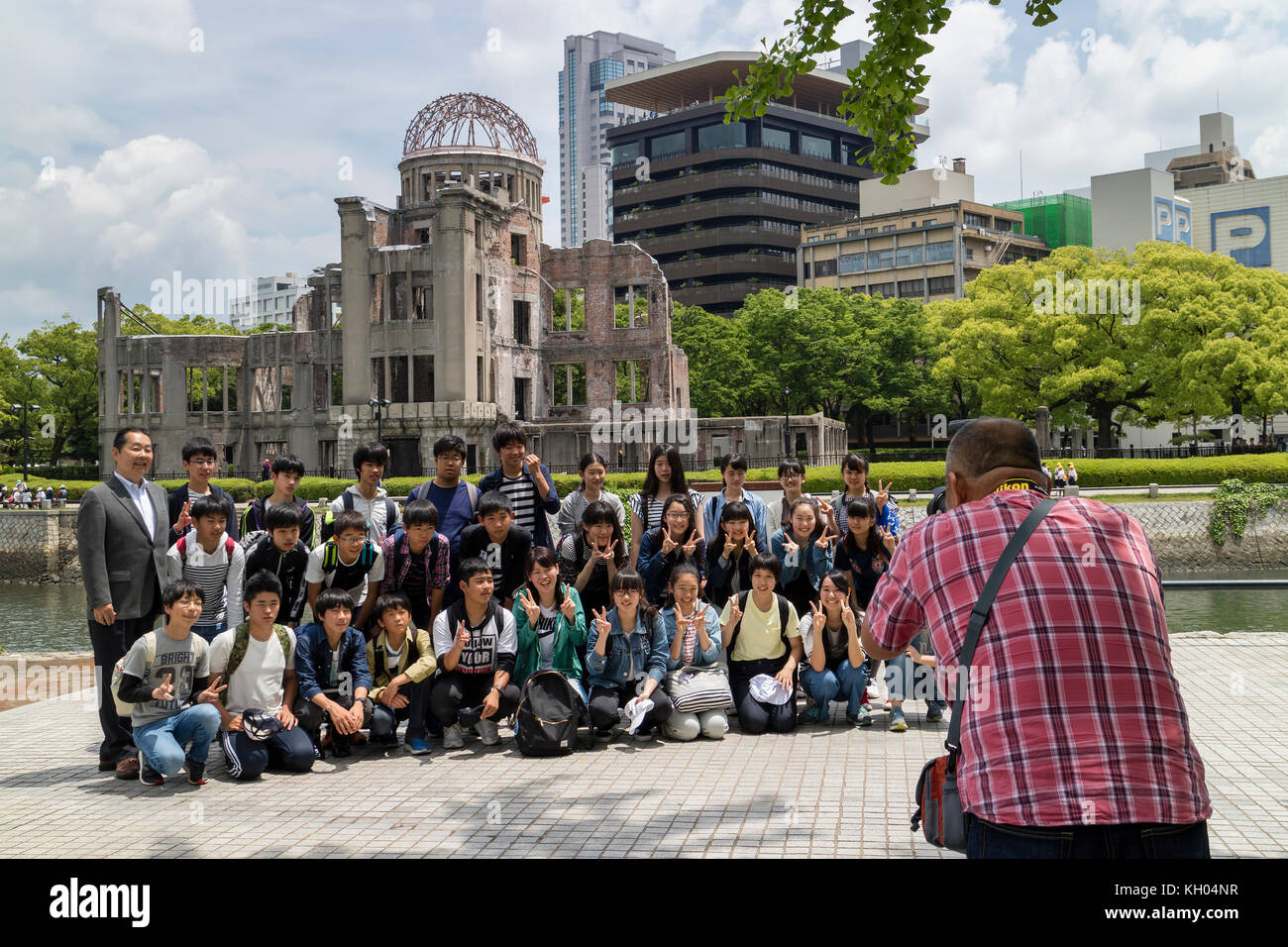 Hiroshima, Japon - 25 mai 2017 : un groupe d'étudiants est photographié dans le parc commémoratif de la paix, Hiroshima avec le dôme de bombe A en arrière-plan Banque D'Images