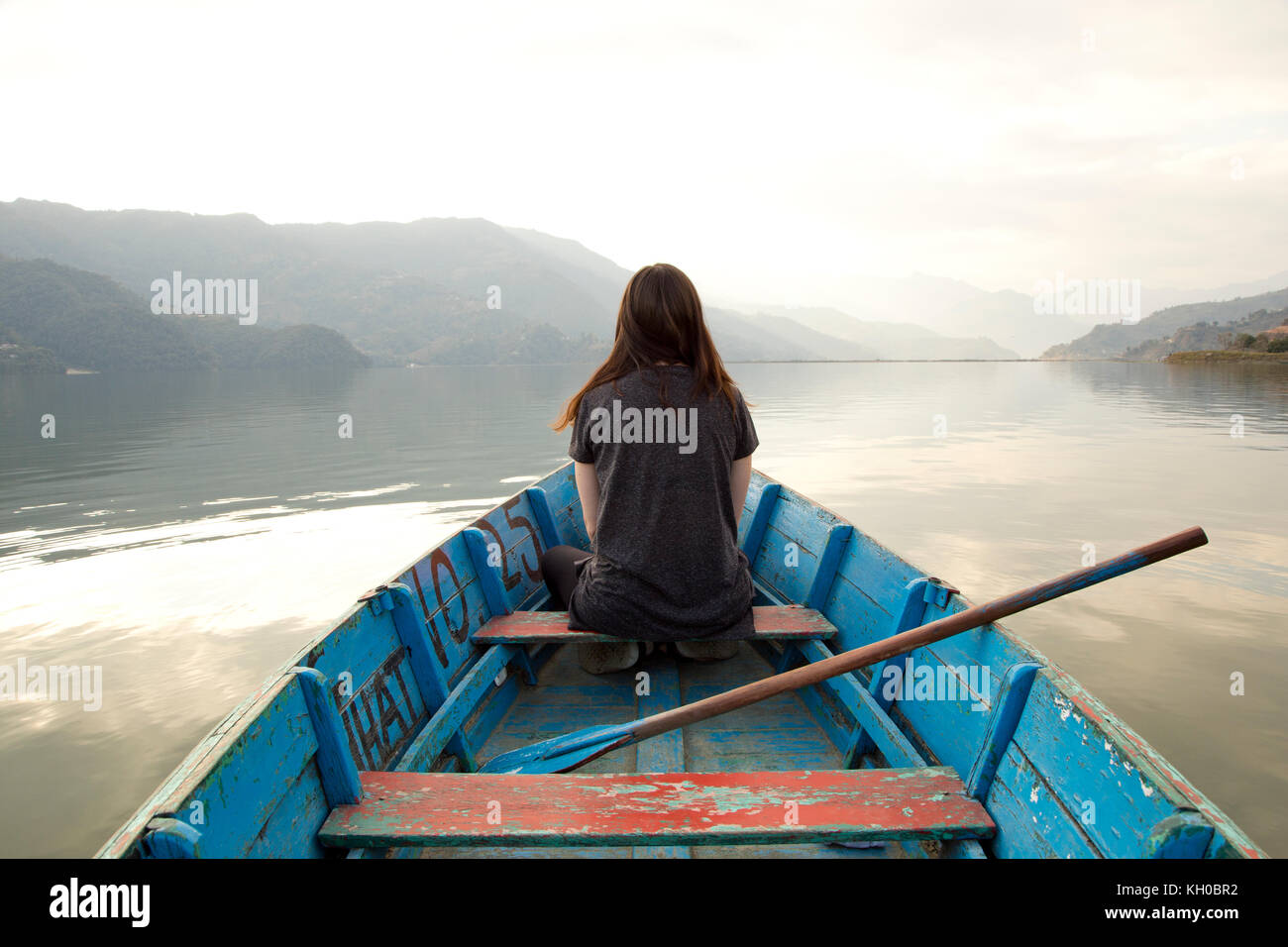 Jeune fille sur un bateau au milieu d'un lac de Pokhara au Népal Banque D'Images