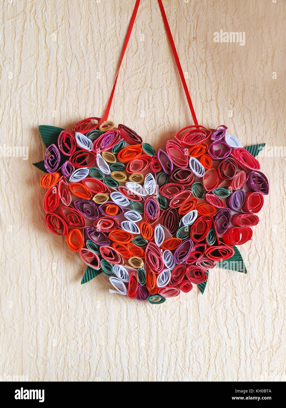 Décoration maison des petits rouleaux de papier de couleur en forme de coeur à suspendre au mur. Banque D'Images