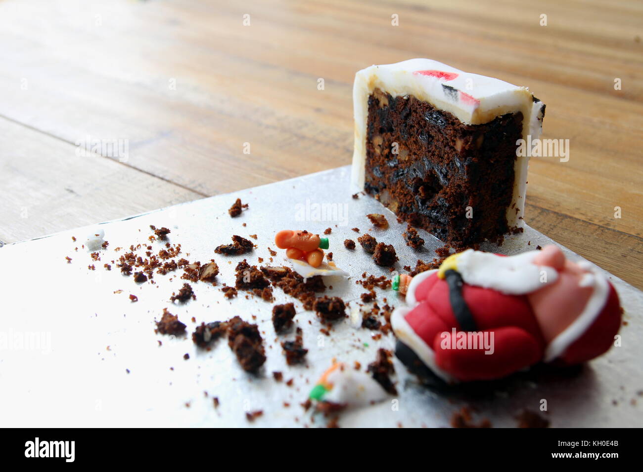 Le tout dernier morceau d'un gâteau de Noël fait maison, avec un père noël, s'est effondré sugarcraft ou santa claus, faites de dégivrage ou du fondant. copy space Banque D'Images