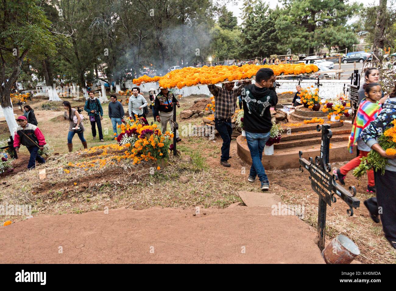 Les membres de la famille tiennent une procession portant des offrandes à la tombe d'un membre de la famille pendant le festival Day of the Dead le 31 octobre 2017 à Tzintzuntzan, Michoacan, Mexique. Banque D'Images