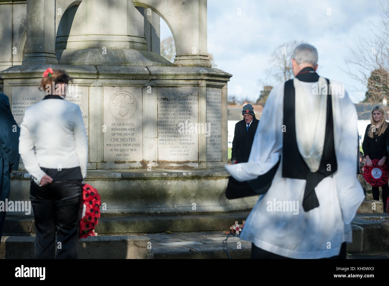 Avec tête baissée, les gens reposer de côté au cours d'une cérémonie du Jour du Souvenir au Monument commémoratif de guerre à Chichester, West Sussex, Angleterre. Banque D'Images