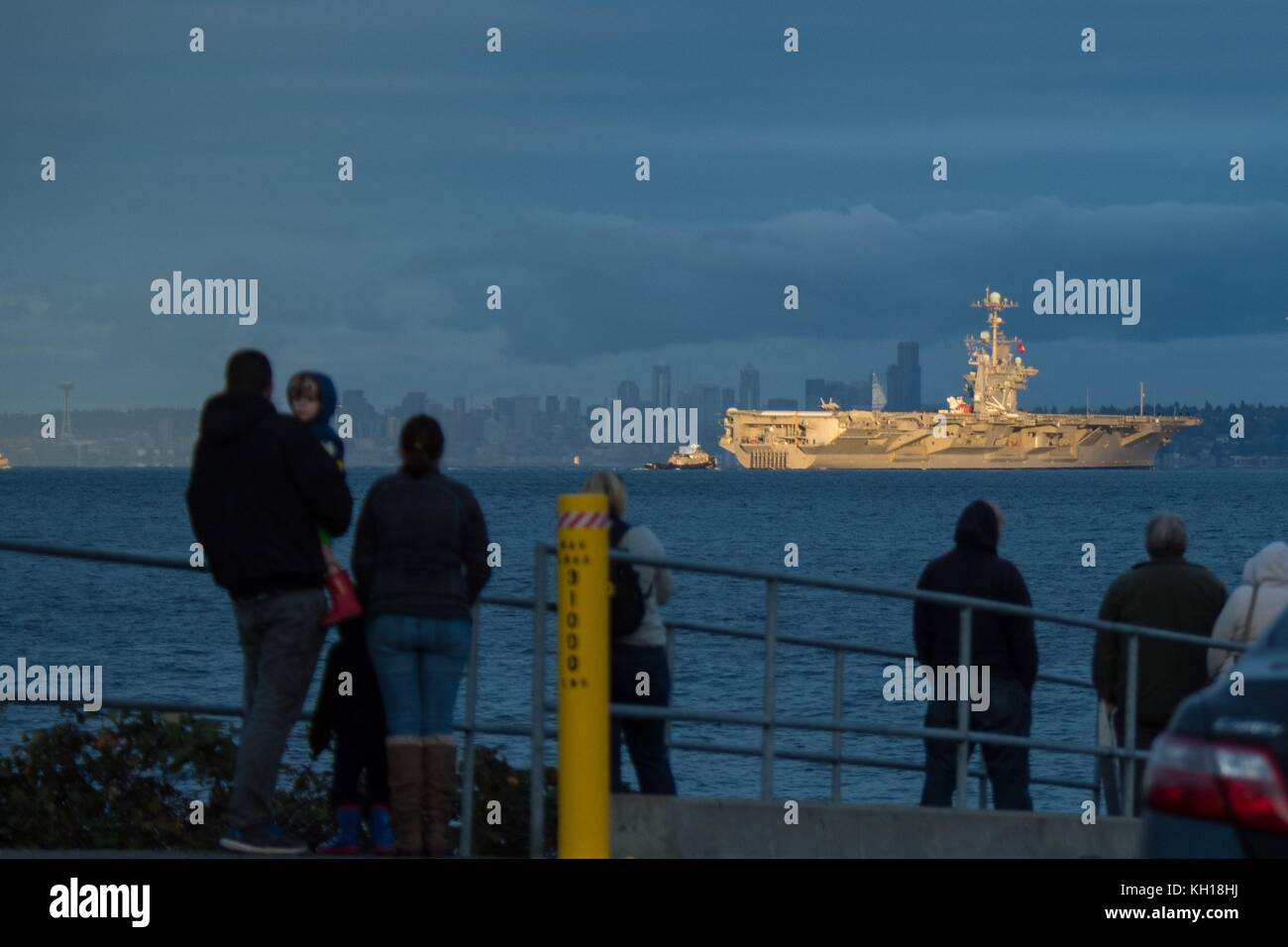 Les gens regardent la marine américaine de classe nimitz porte-avions USS John C. Stennis transite l'Elliott Bay avec le Seattle City skyline en arrière-plan le 3 novembre 2017 à Manchester, dans l'État de Washington. (Photo de vaughan dill via planetpix) Banque D'Images