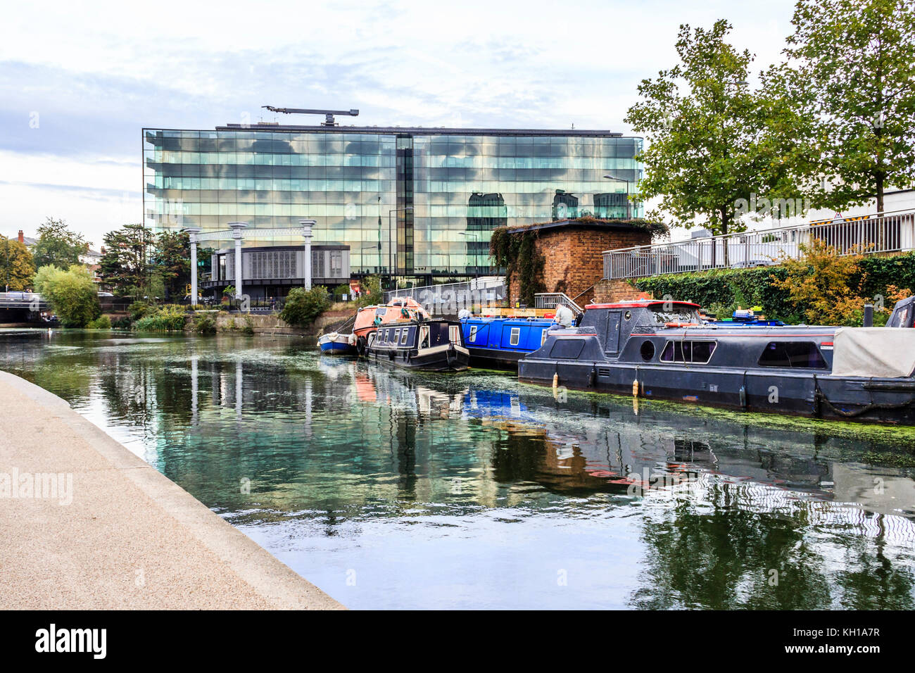 Narrowboats amarrés sur Regent's Canal à King's Cross, Londres, Royaume-Uni, la façade en verre du bâtiment Place du Roi dans l'arrière-plan, 2017 Banque D'Images