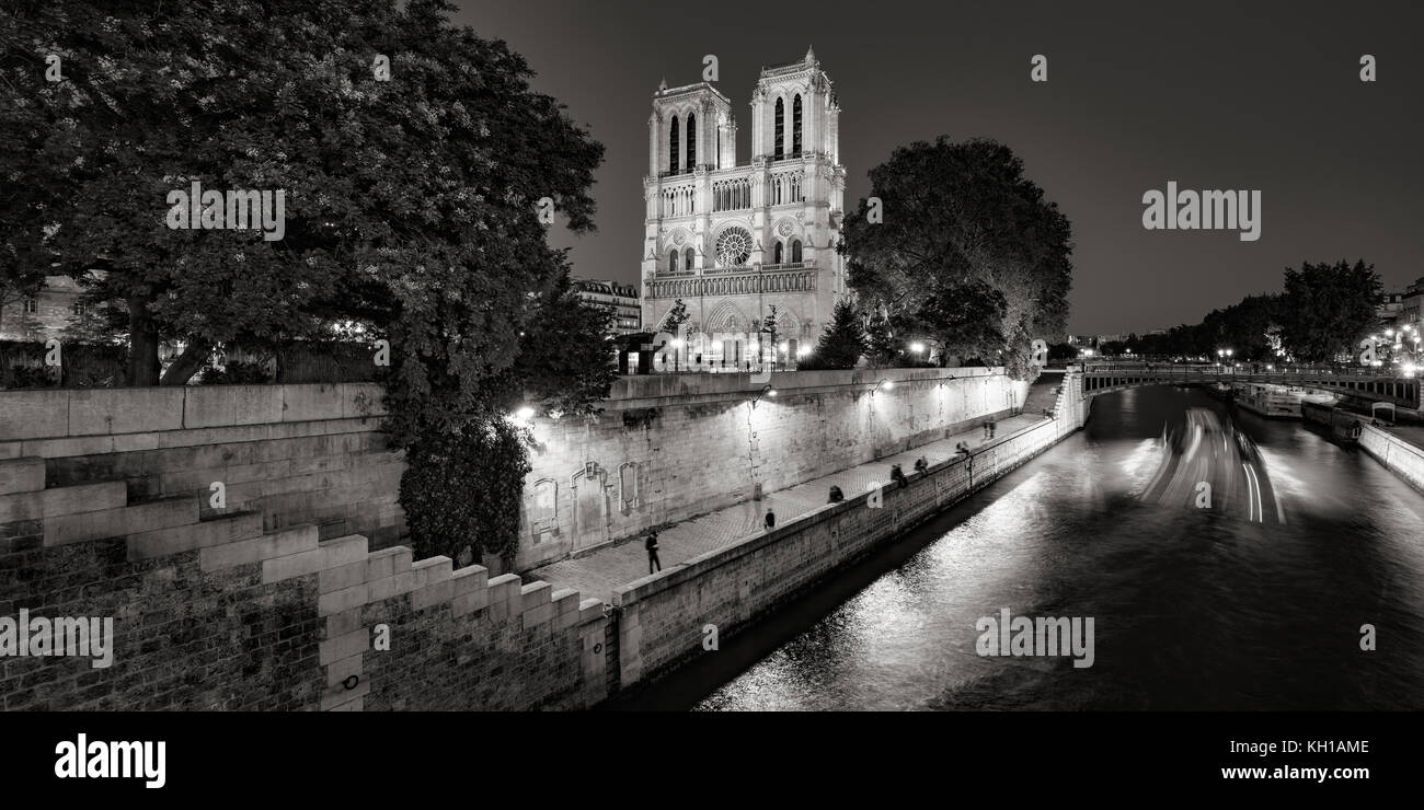Le noir et blanc de Notre Dame de Paris Cathédrale illuminée au crépuscule avec la Seine sur l'Ile de La Cité. Paris, France Banque D'Images