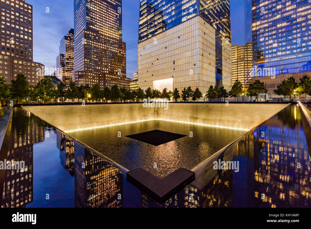 L'Amérique du miroir d'eau au crépuscule lumineux avec vue de One World Trade Center. Lower Manhattan, 9/11 Memorial & Museum, New York City Banque D'Images