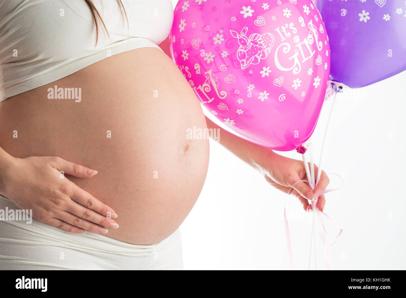 Ventre de femme enceinte et de ballons isolé sur blanc. Concept de la grossesse. Banque D'Images