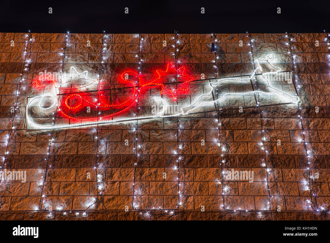 Profil de le traîneau et les rennes du Père Noël avec des lumières de Noël rouge et blanc dans la nuit. Noël arrière-plan Banque D'Images