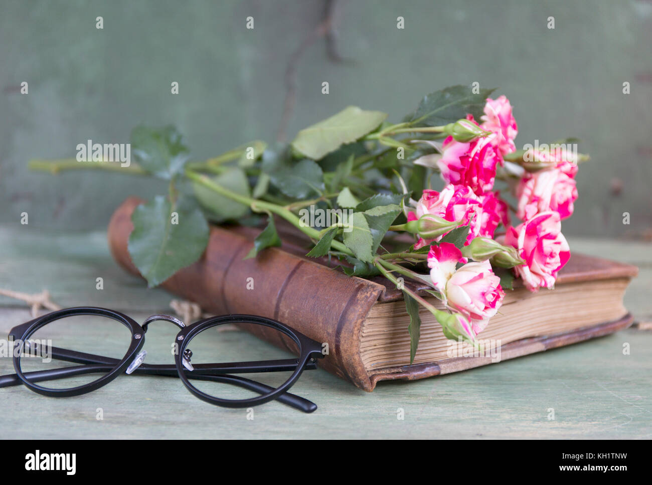 Ordinateur portable vintage des maquettes de l'art avec des roses roses. place pour le texte. Des fleurs fraîches et des lunettes noires. Banque D'Images