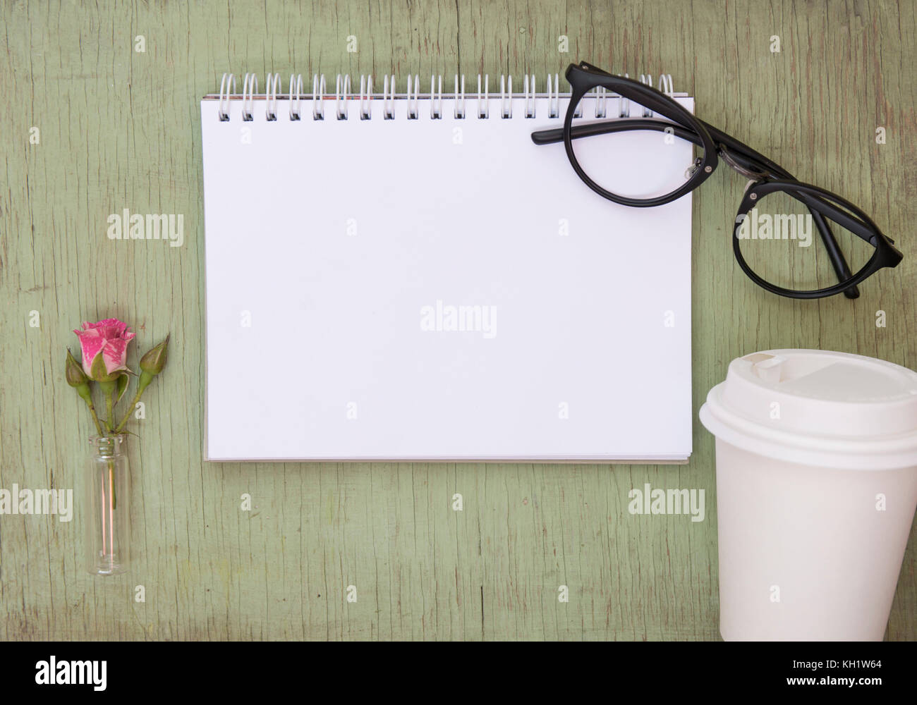 Ordinateur portable blanc des maquettes pour l'oeuvre avec rose rose et noir lunettes. place pour le texte. des fleurs. café d'aller cup. Banque D'Images