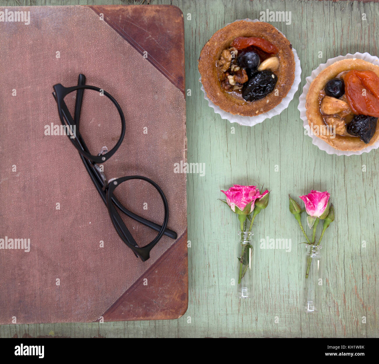 Ordinateur portable vintage des maquettes de l'art avec des roses et des gâteaux. place pour le texte. Des fleurs fraîches et des lunettes noires. Banque D'Images