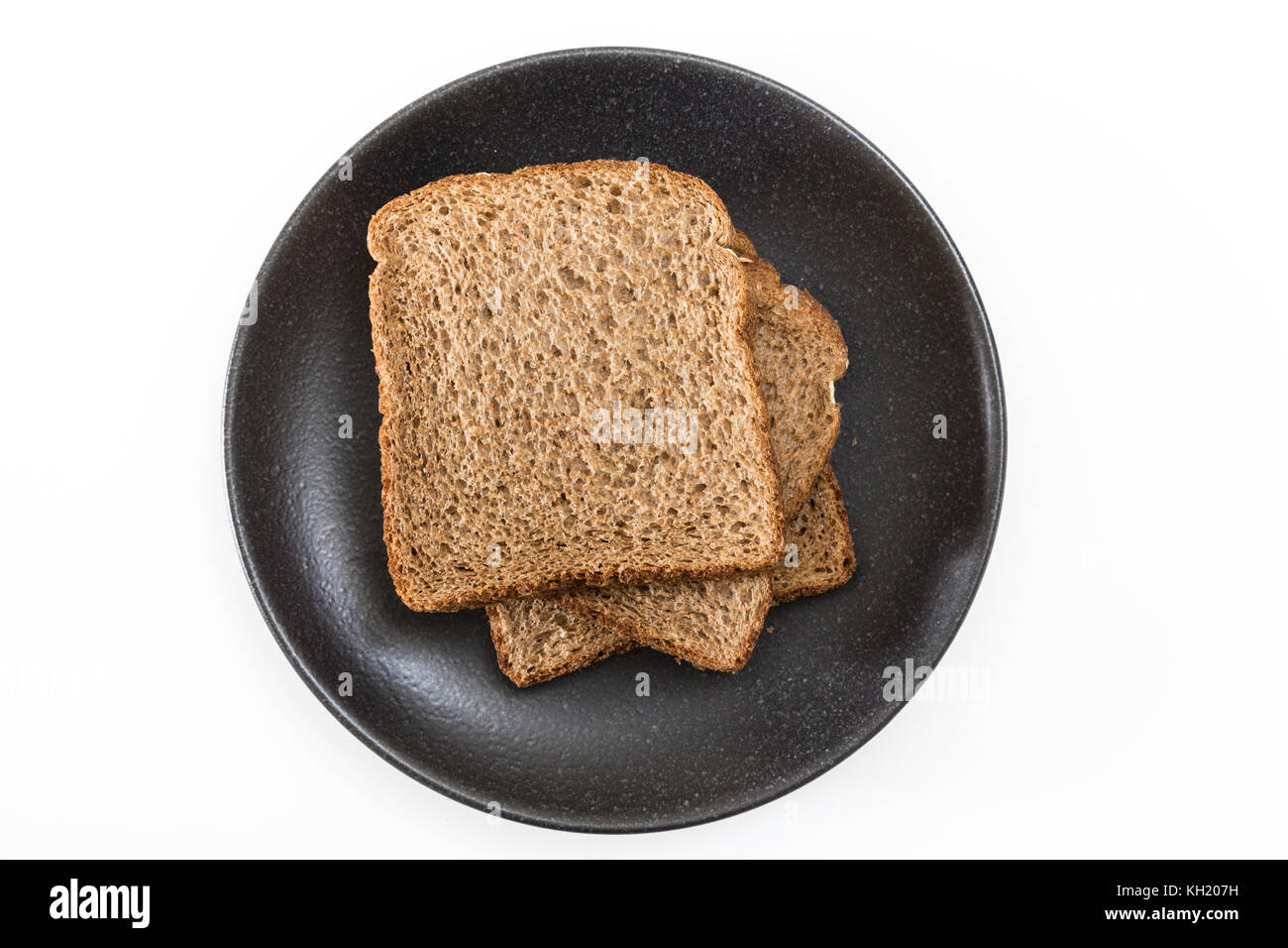 Les tranches de pain à sandwich de grains entiers sur plaque, sur fond blanc. Banque D'Images