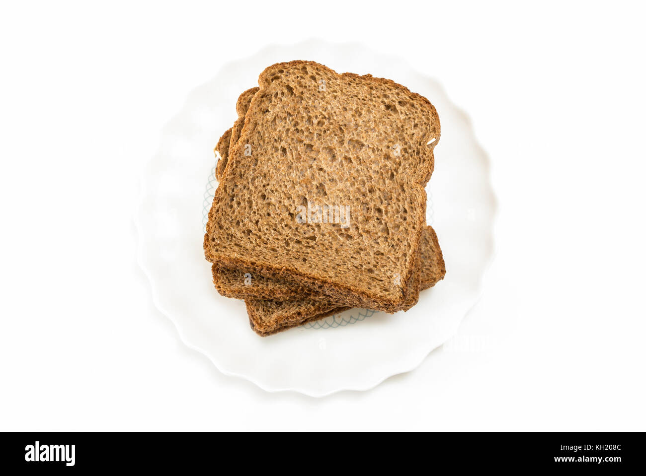 Les tranches de pain à sandwich de grains entiers sur plaque, sur fond blanc. Banque D'Images
