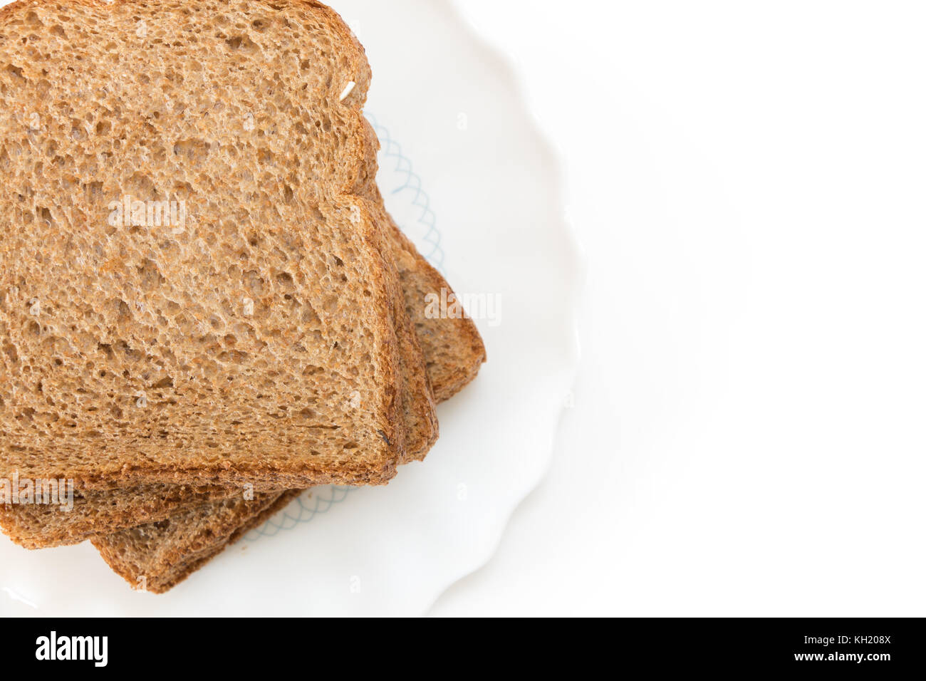 Les tranches de pain à sandwich de grains entiers sur plaque, sur fond blanc. Banque D'Images