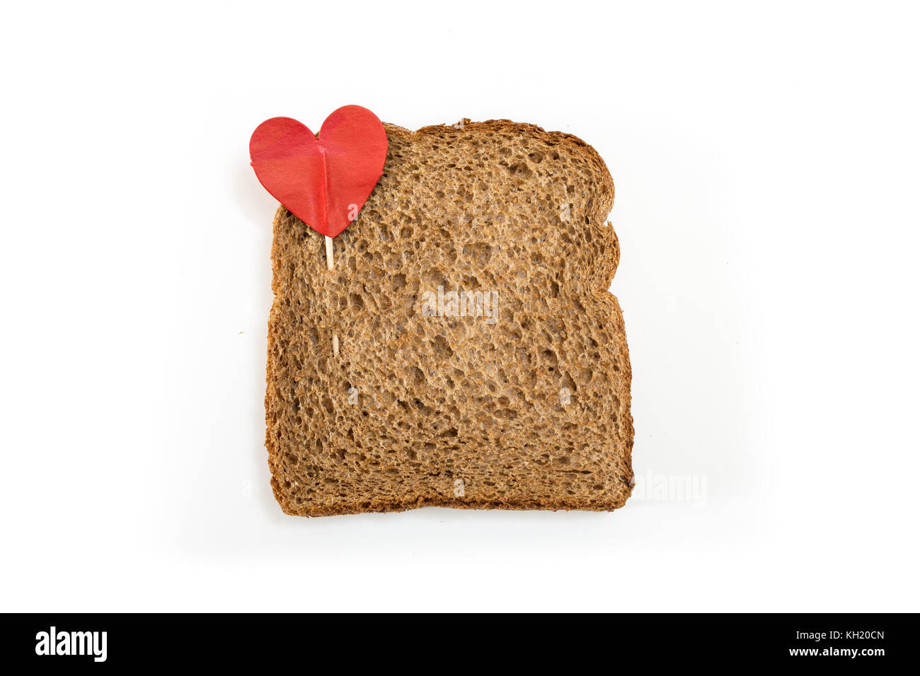 Tranche de pain sandwich de grains entiers avec broche coeur, sur fond blanc. Banque D'Images