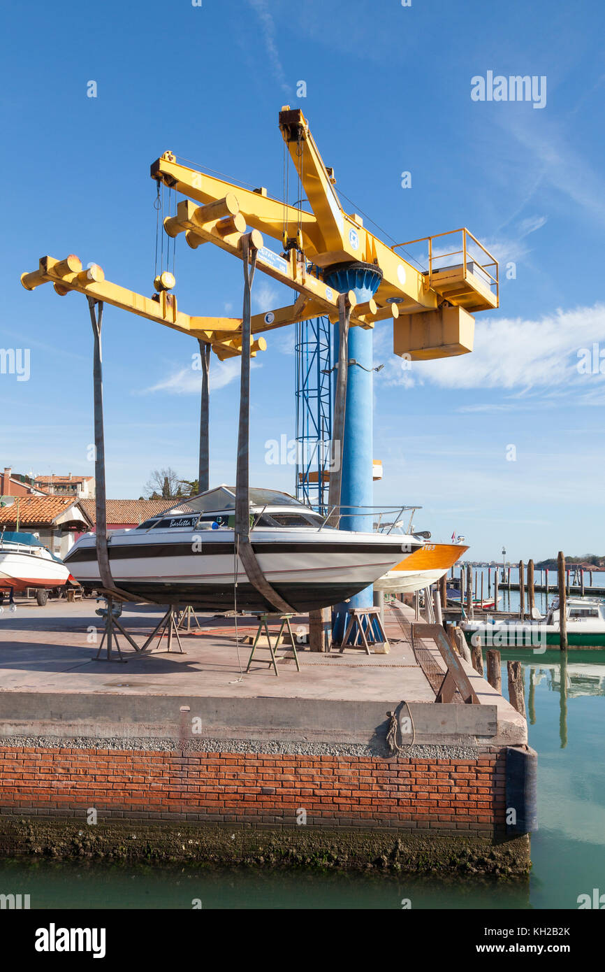 Voile sur les harnais suspendu sur un élévateur pour l'entretien ou service en chantier de la Giudecca, à Venise, l'Italie au bord du quai sur la lagune. Banque D'Images