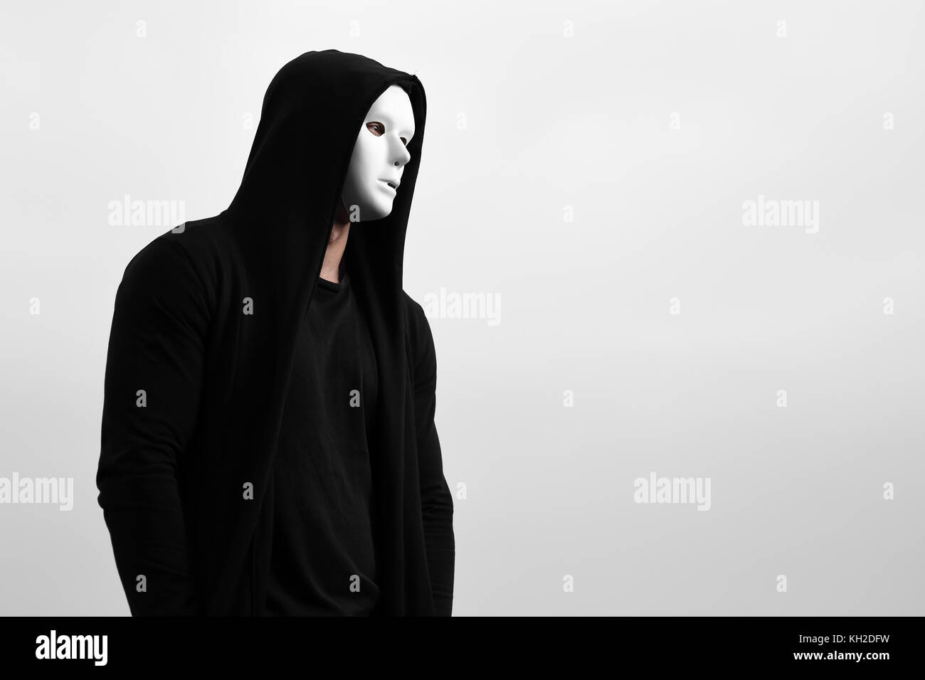 Portrait d'homme en noir vêtu de blanc à capuche masque anonyme. Banque D'Images
