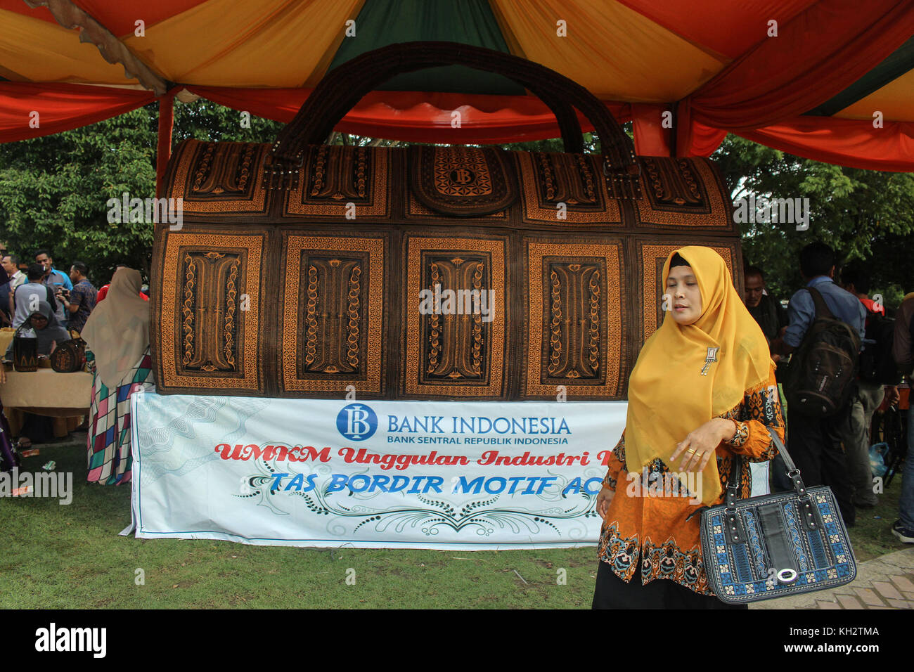 Lhokseumawe, Aceh, Indonésie. 12 nov, 2017. femme passer devant le monde entier plus grand sac à main.Ce grand sac à main est le travail de l'Aceh a repéré par la banque d'Indonésie a été enregistré comme le record du monde musée (muri) le 12 novembre 2017, parce que sa valeur unique est unie à la porte de l'Aceh, motif qui est caractéristique de la société acéhnites la culture. L'objectif est de réduire le taux de chômage et d'accélérer la croissance économique de l'ensemble de la communauté. crédit : sopa/zuma/Alamy fil live news Banque D'Images