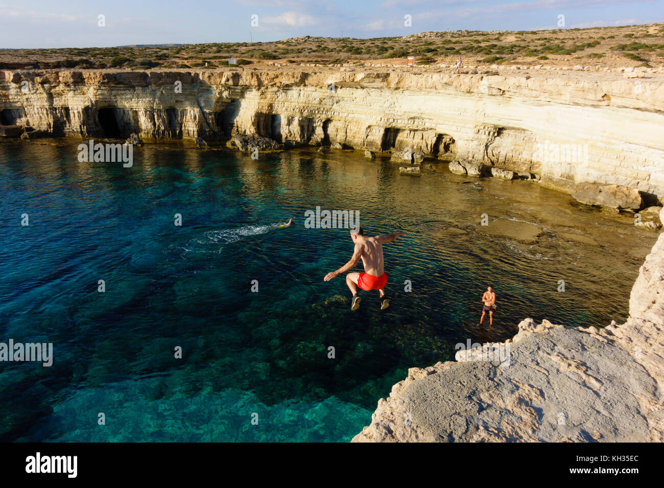 Young male tourist passe de la falaise, Cape Greco seacaves, Chypre Banque D'Images