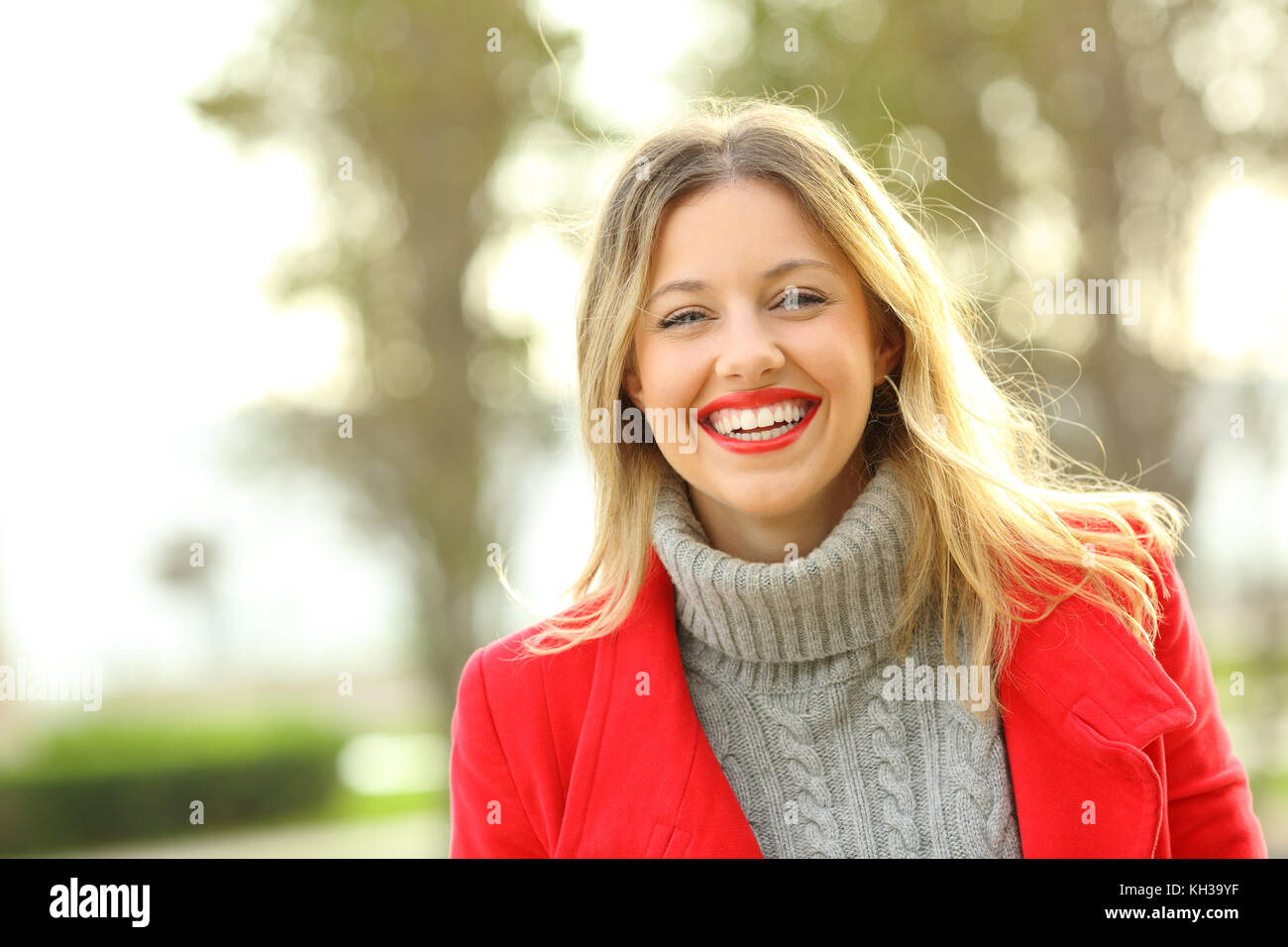 Portrait of a happy woman laughing wearing red jacket and looking at camera en hiver Banque D'Images