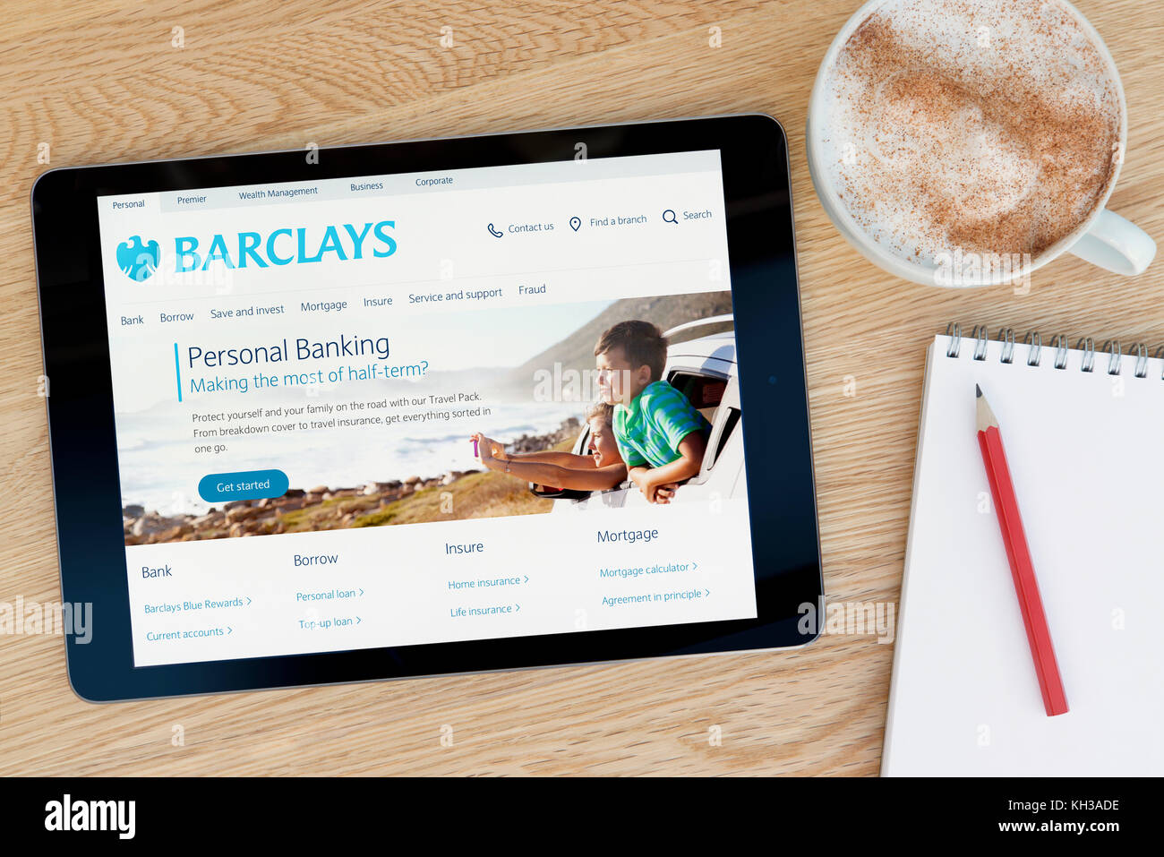Le site web dispose d'un sur Barclays iPad tablet device qui repose sur une table en bois à côté d'un bloc-notes et un crayon et une tasse de café (rédaction uniquement) Banque D'Images