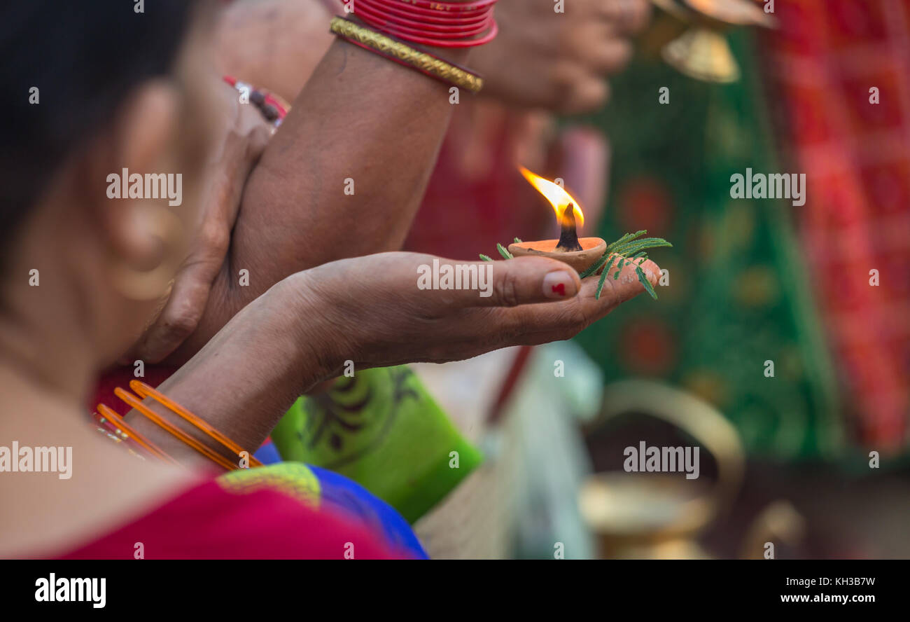 Femme hindoue indienne main tenant une lampe d'argile à la main et une plante sacrée pour offrir dans le Gange comme partie d'un rituel à Varanasi en Inde. Banque D'Images