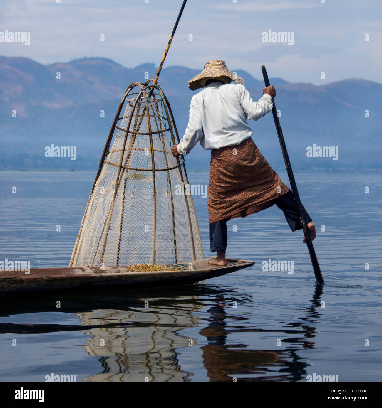 Une jambe l'aviron pêcheur sur le lac Inle dans l'État Shan au Myanmar (Birmanie).Ce style unique de l'aviron a évolué parce que le fond du lac peu profond est couvert par Banque D'Images