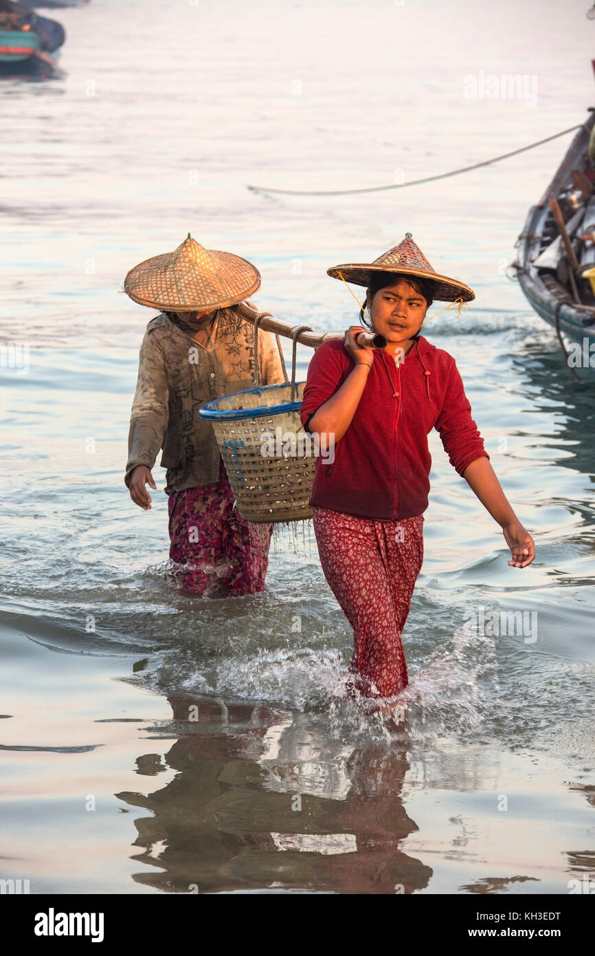 Les birmanes réunissant les nuits à terre des prises à l'aube, près du village de pêcheurs sur la plage de Ngapali en Birmanie (Myanmar). Banque D'Images