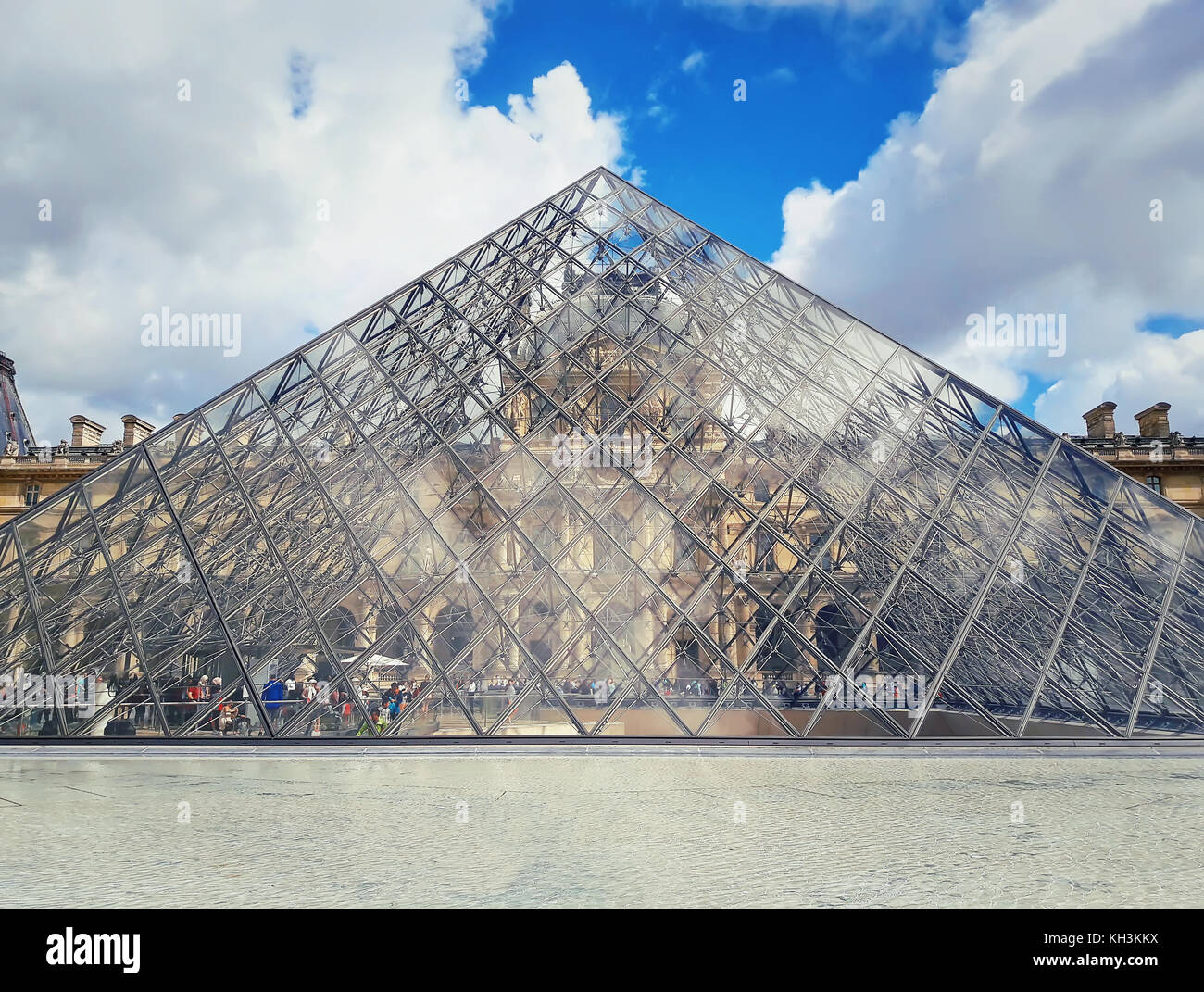 Vue sur la pyramide de verre et la fontaine dans la cour du musée du Louvre. Banque D'Images