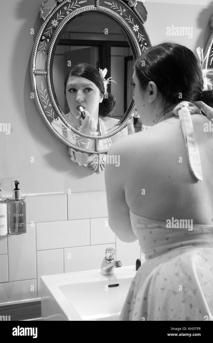 Girl putting lipstick sur tout en se regardant dans le miroir Banque D'Images