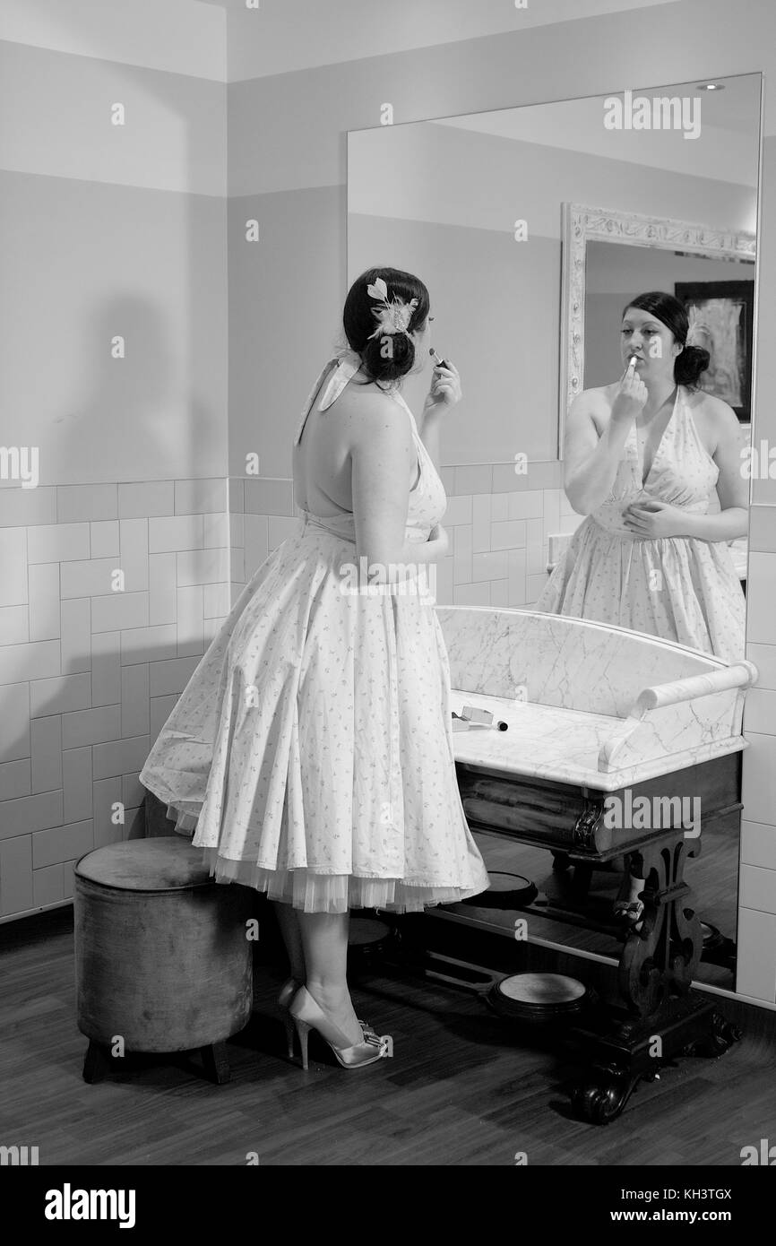 Girl putting lipstick sur tout en se regardant dans le miroir Banque D'Images