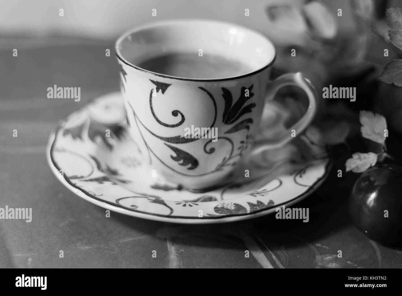 Une boisson chaude servie dans une élégante tasse entouré par les feuilles d'automne, les noix et les bâtons de cannelle Banque D'Images
