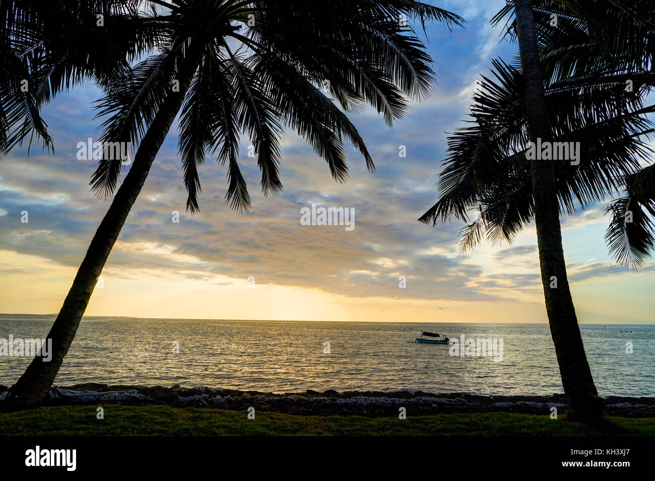 Coucher du Soleil Plage avec palmiers ciel bleu et nuages Lombok Banque D'Images