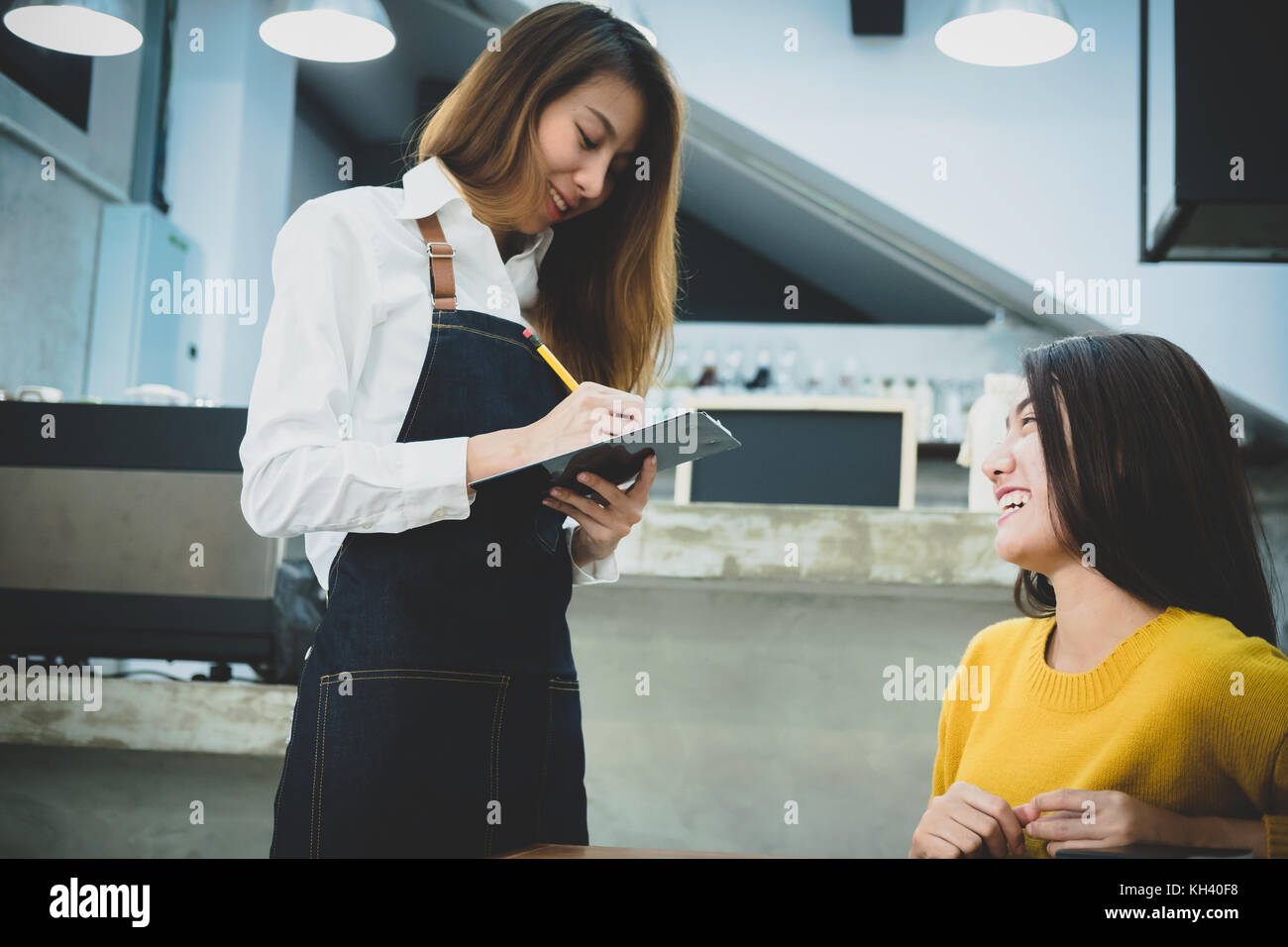 Jeune asiatique prise barista ordre de femme dans le café. café restaurant service, propriétaire de petite entreprise, l'industrie alimentaire et des boissons concept. Banque D'Images