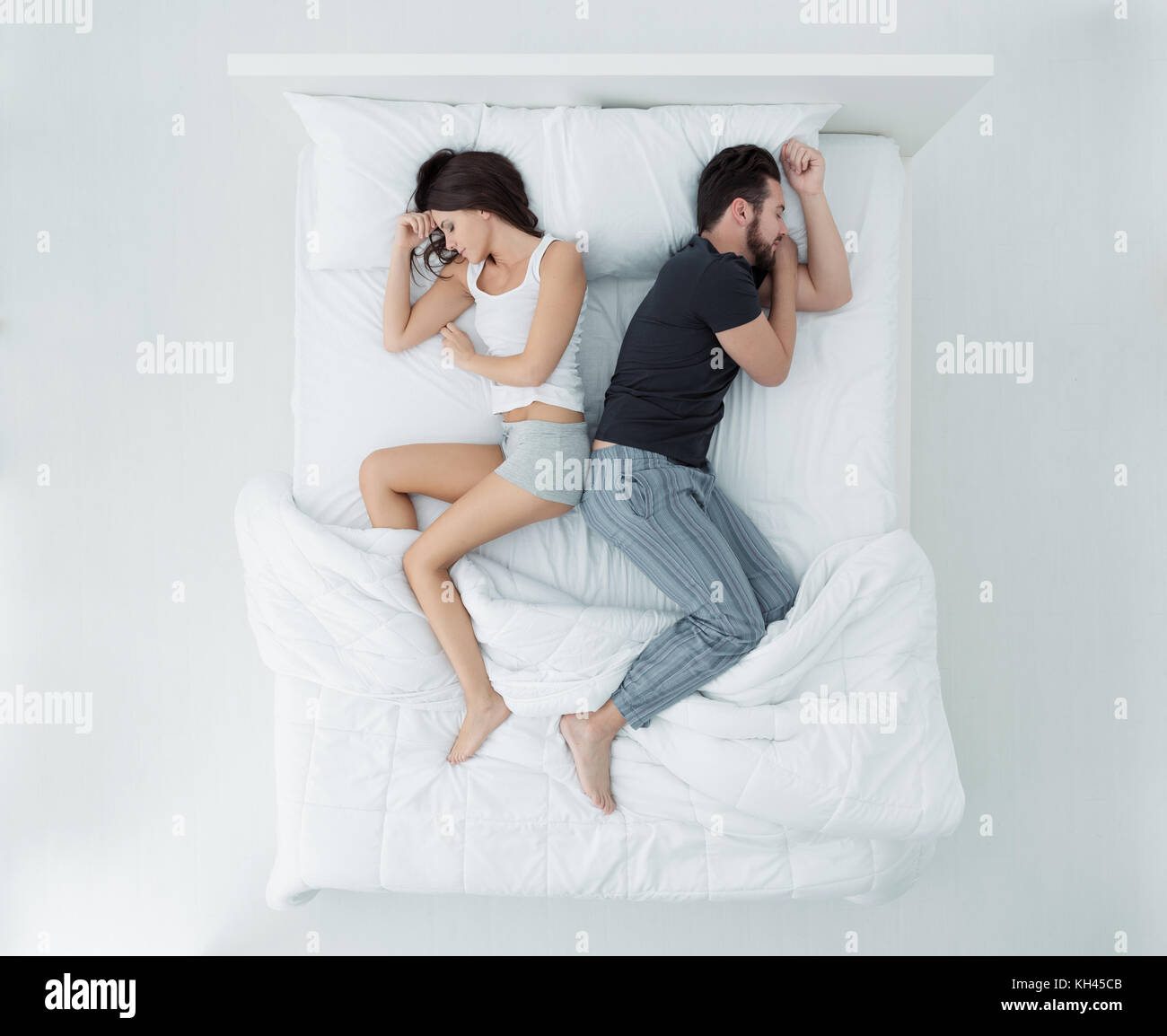 Couple dans le lit dos à dos, vue du dessus Banque D'Images