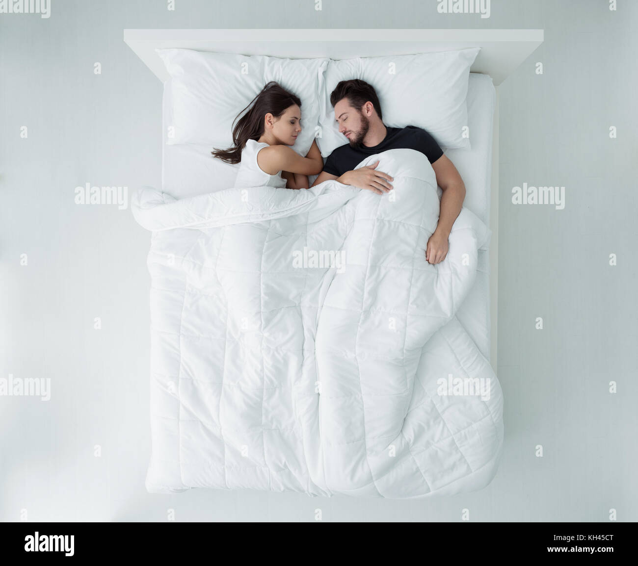Couple aimant se détendre et dormir dans le lit, vue du dessus Banque D'Images