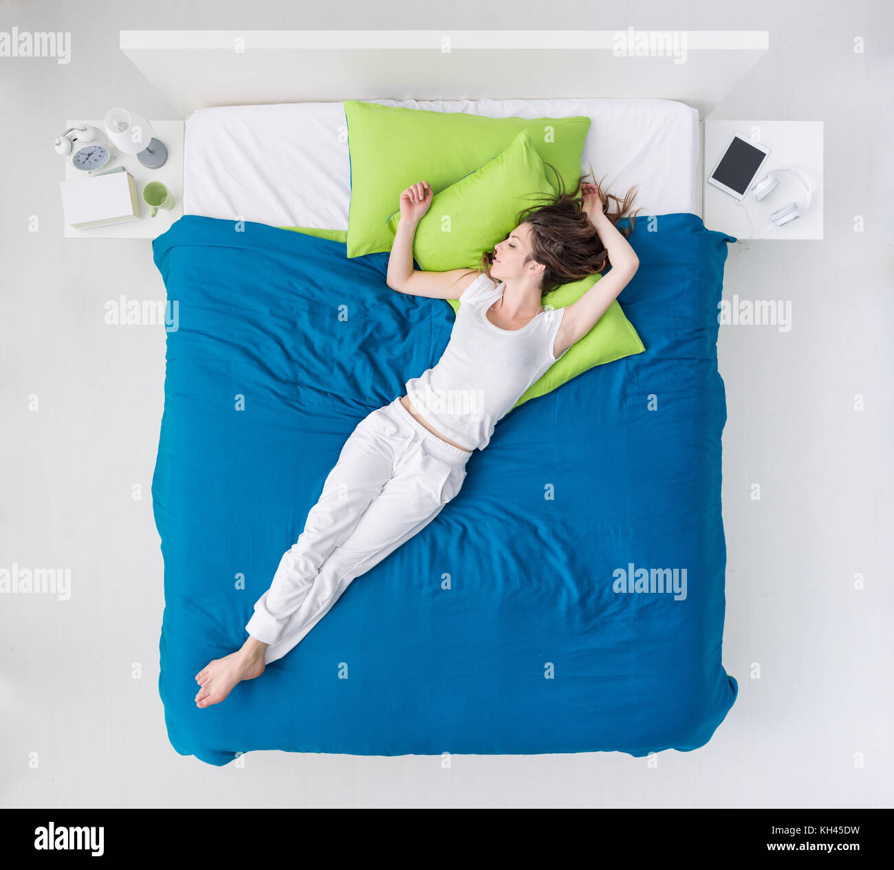 Jeune femme dormir dans sa chambre, elle est couchée sur le haut de la couverture Banque D'Images