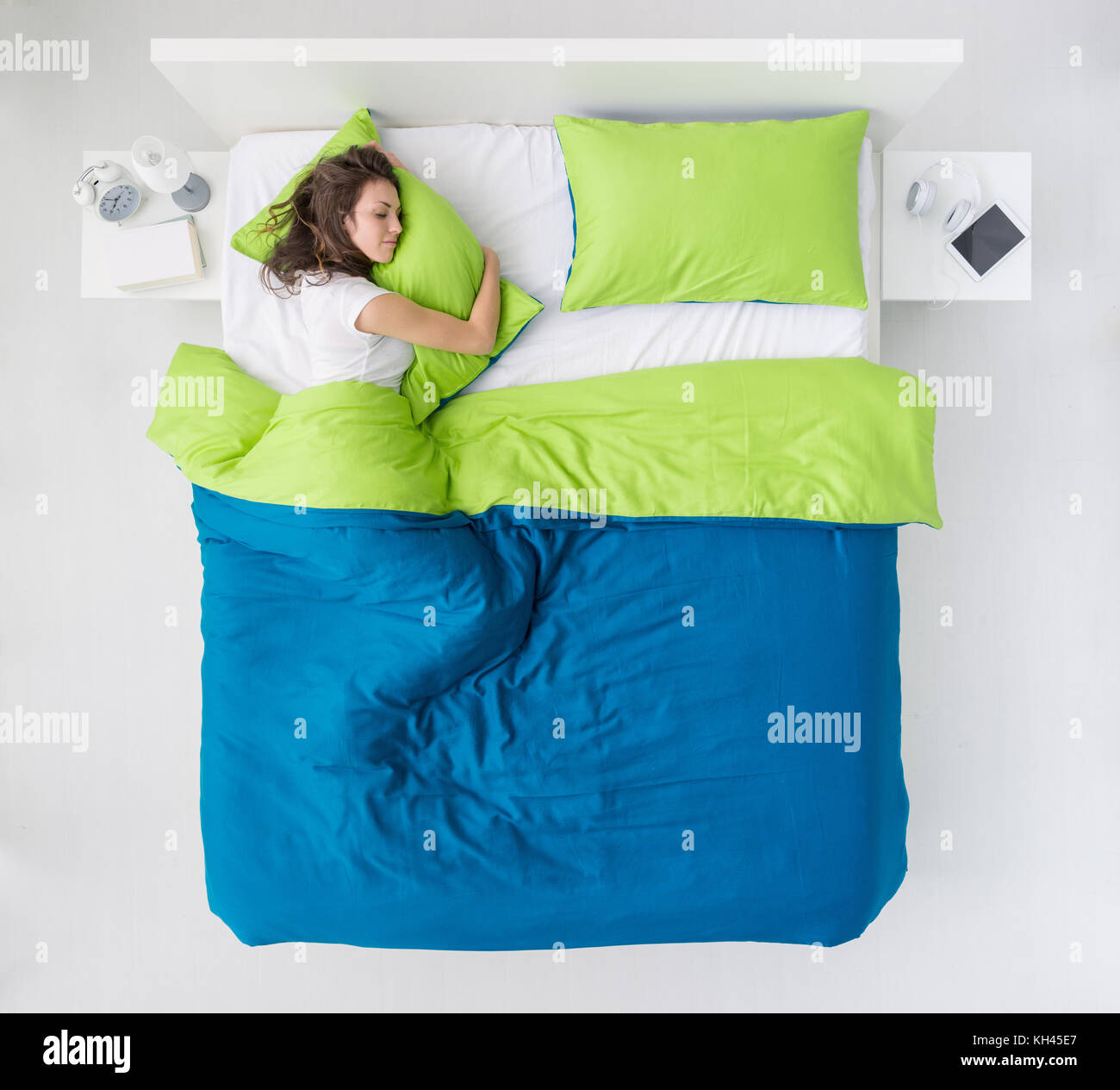Jeune femme dormant dans la chambre à coucher et serrant un oreiller soft, vue du dessus Banque D'Images