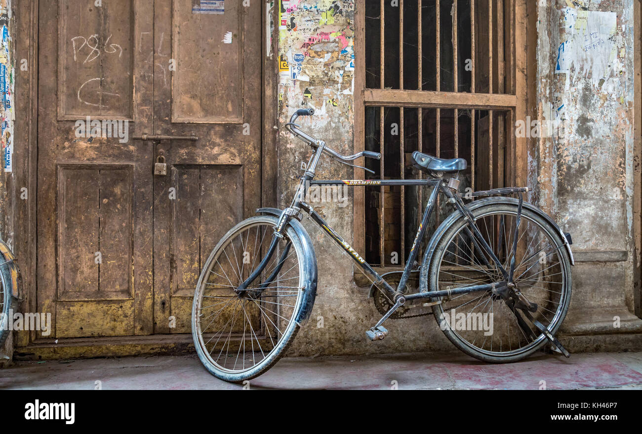 Old rusty vélo à la porte d'une maison dans une ruelle à Varanasi, Inde. Banque D'Images