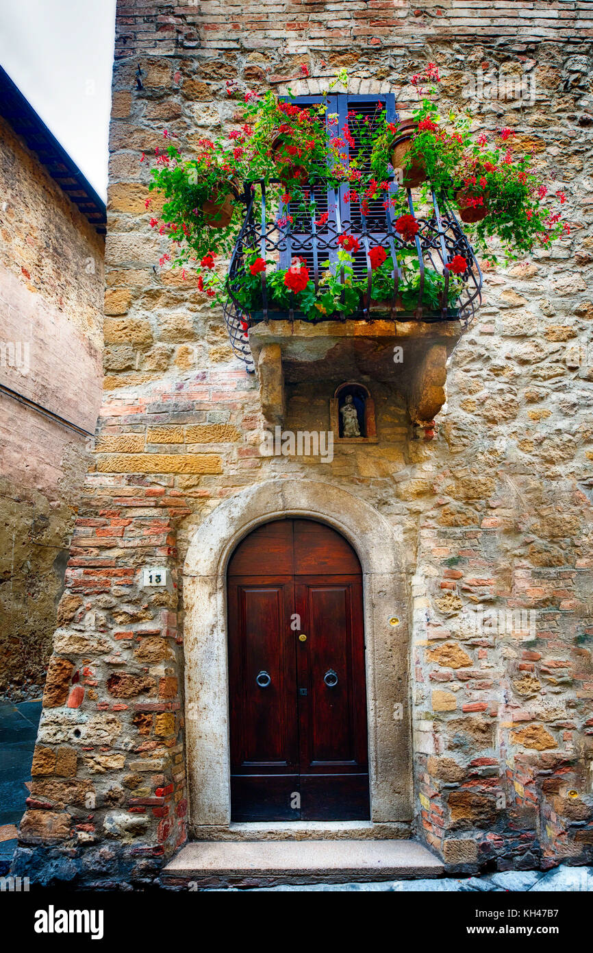 Porte d'entrée d'un mediavel chambre et un petit balcon avec des fleurs, Pienza, toscane, italie Banque D'Images