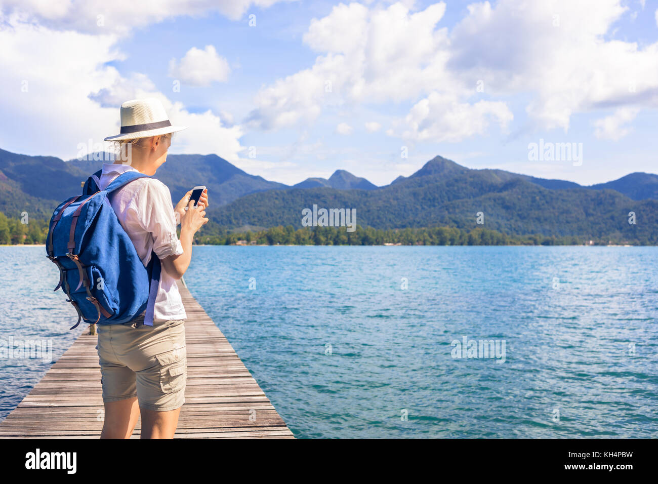 Sac à dos avec female traveler looking at smartphone site en visitant une île tropicale, destination aventures voyages vacances Banque D'Images