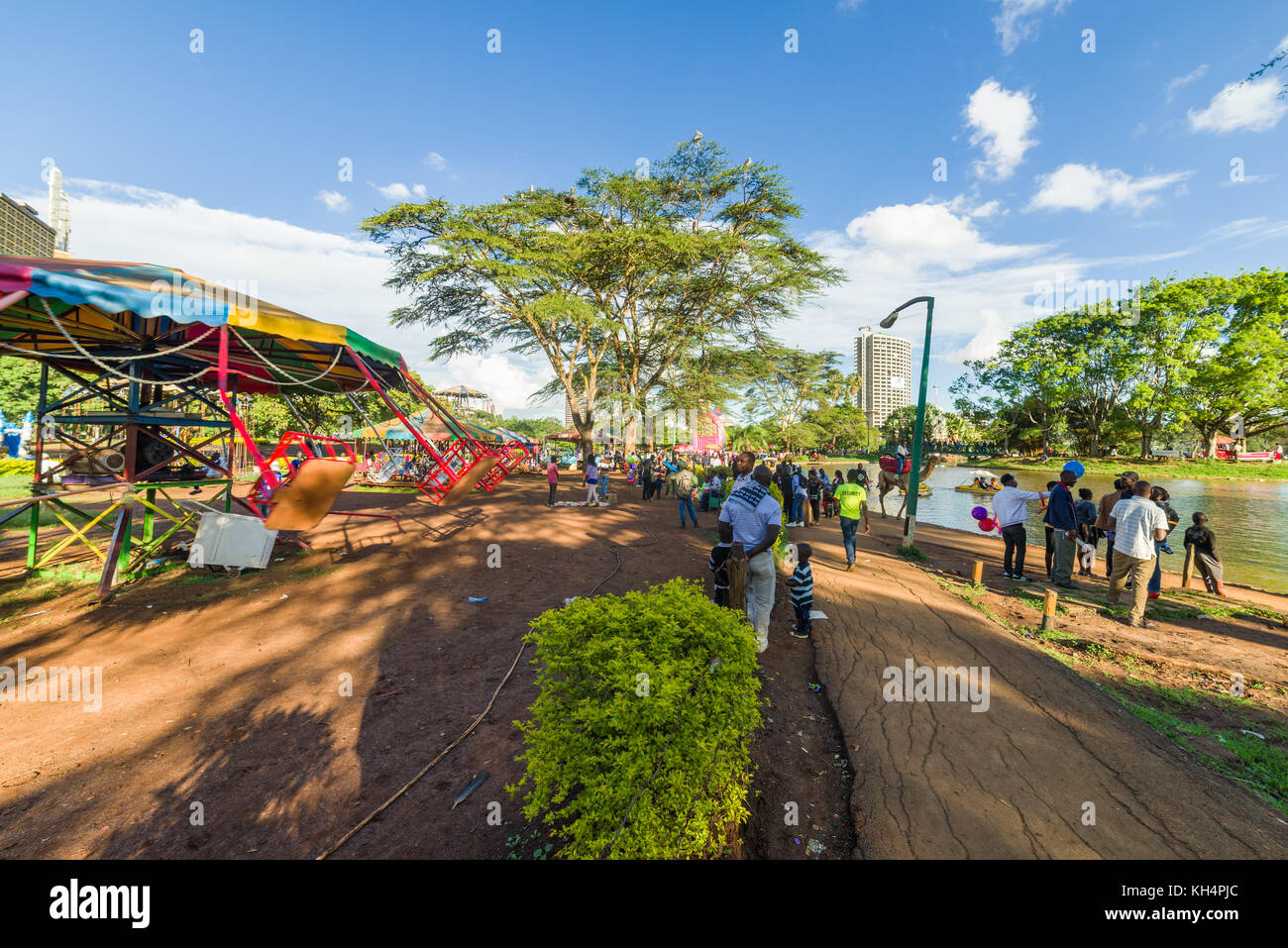 Parc pour enfants ainsi que des personnes marcher dans Uhuru Park par le lac en fin d'après-midi, lumière, Nairobi, Kenya Banque D'Images