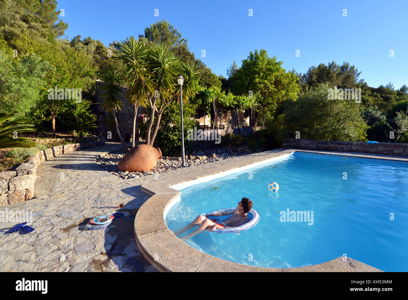 Teenage boy jumping dans une villa privée piscine Banque D'Images