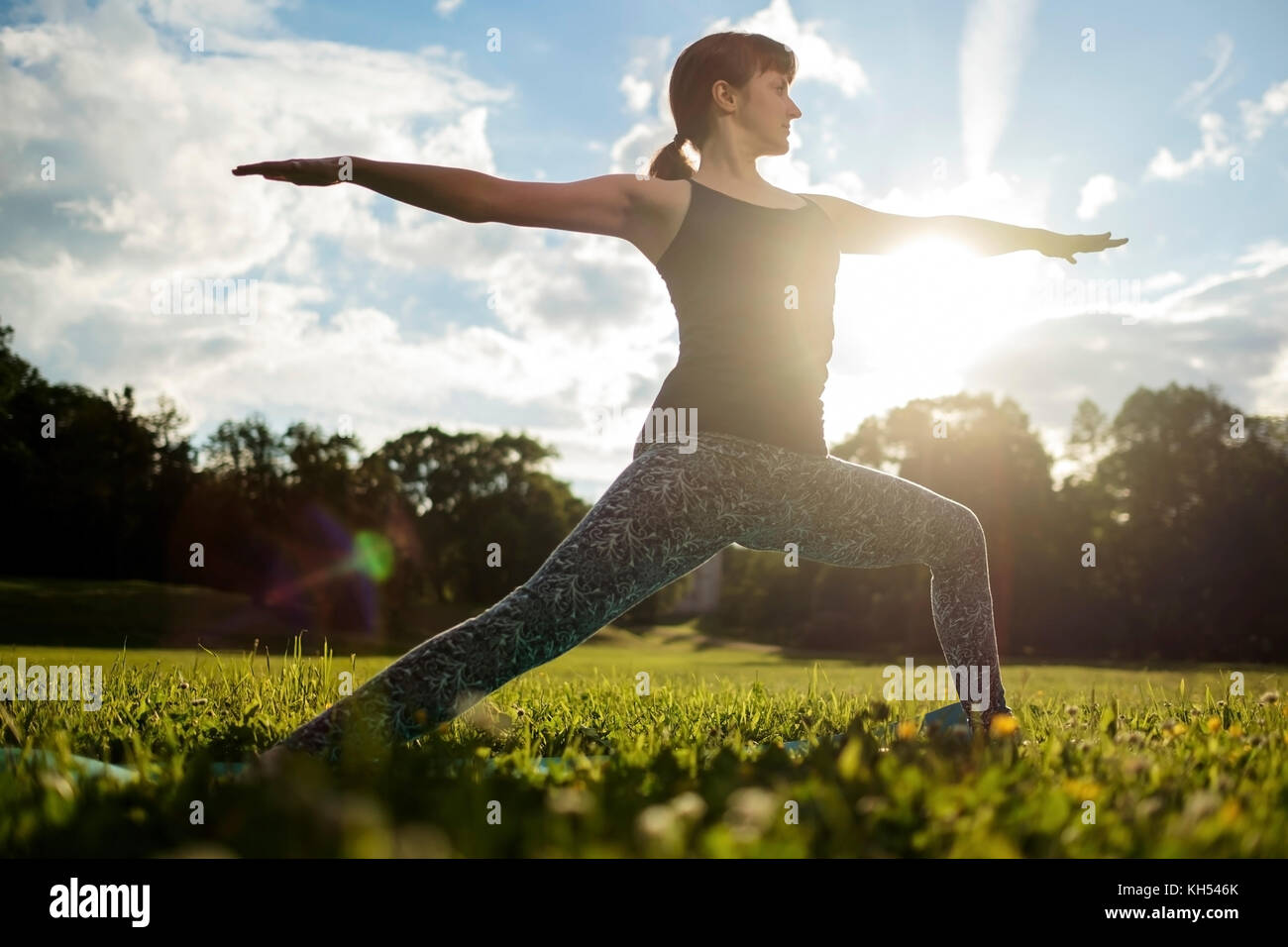 Belle jeune femme caucasienne pratique le yoga asana Virabhadrasana 1 Banque D'Images